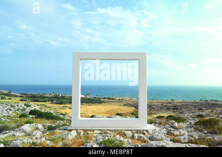 La scultura in pietra simile a un telaio sullo sfondo del mare di Cipro, Ayia Napa. Vista sul mare attraverso il telaio. Foto Stock