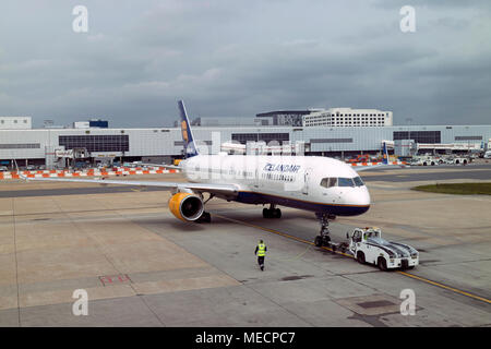 Dall'Aeroporto Gatwick di Londra, Surrey, Regno Unito 2018. Rimorchiatore spinge un Icelandair Boeing 757-200 jet del passeggero per la pista di rullaggio Foto Stock