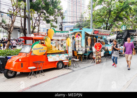 La gente camminare passato carrelli di cibo, Bangkok, Thailandia Foto Stock