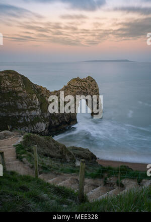 Le luci del tramonto fino Durdle porta, con gradini che conducono in basso verso la spiaggia Foto Stock