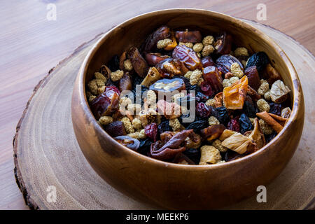 Frutta secca (noce, fig, palm, gelso, data) in una ciotola di legno. Alimenti biologici. Foto Stock