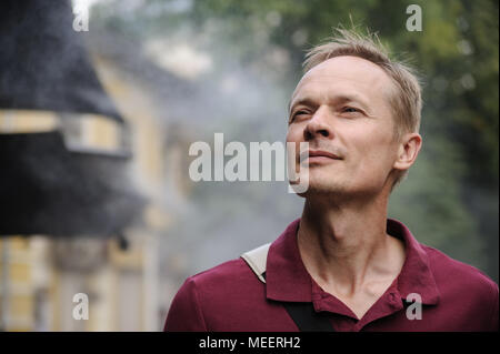 L'uomo sta godendo la freschezza della nebbia. Sistemi di raffreddamento per esterni. Sistemi di appannamento. Foto Stock