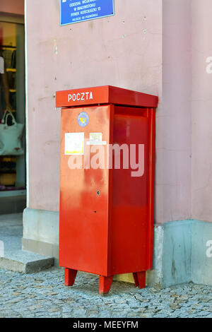 Bialystok, Polonia - 30 Aprile 2012: rosso metallico della cassetta postale nazionale e internazionale polacco di stato del servizio postale si erge a muro sulla pavimentazione in pietra. Lettera Foto Stock