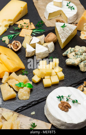 Vari tipi di formaggio - brie, camembert roquefort e il cheddar su calcestruzzo Foto Stock