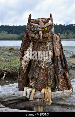 Gli artisti locali producono una grande gufo cornuto da driftwood, conchiglie e gli elementi che entrano in con la marea a Esquimalt laguna. Foto Stock