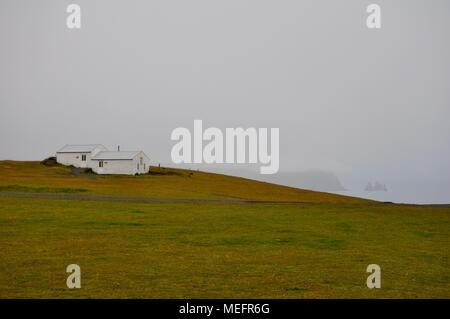 Cabina di bianco su una collina erbosa, Islanda Foto Stock