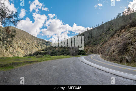 Ampio angolo di immagine dell'autostrada curvando verso le montagne con un cielo azzurro Foto Stock