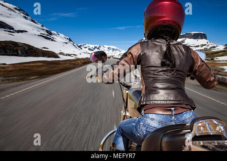 Biker ragazza scorre una strada di montagna in Norvegia. Visuale in prima persona. Foto Stock