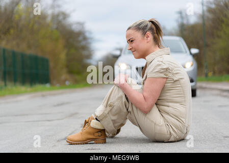 Un ferito giovane donna incontrano gravi dolori causati da ginocchio distorsione o frattura dopo incidente d'auto. Foto Stock