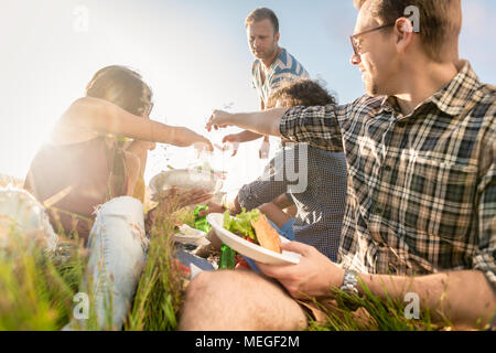 Gli amici di estate picnic barbecue e mangiare insieme Foto Stock