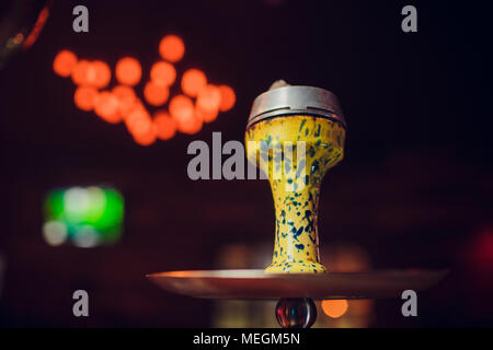 Preparare il shisha, aka nargile o hookah presso un ristorante ponendo i carboni di legna sulla parte superiore. Foto Stock