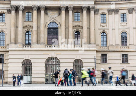 Berlino, Germania. Xvi Apr, 2018. Visitatori guardano la Bebelplatz Memorial a Berlino, Germania, Lunedì 16 Aprile 2018.Il Bebelplatz memorial è stato inaugurato nel 1995, ed è il lavoro di artista israeliano Micha Ullman. Si tratta di un set di lastre di vetro in pietre per pavimentazione, e sotto di esso vi è una sala sotterranea con scaffali vuoti.Bebelplatz è noto come il sito di uno dei famigerati libro nazista la masterizzazione di cerimonie, svoltasi il 10 maggio 1933. Membri della Germania nazista Student Union e i loro professori bruciate circa 20.000 libri come parte di una azione capillare di 'contro le nazioni unite-spirito tedesco.". Foto Stock