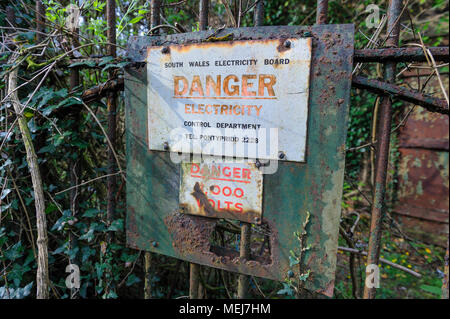 Corroso segno di avvertimento al di fuori di un abbandonato South Wales Electricity Board facility, Galles del Sud Foto Stock