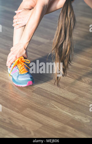 Chiudere uo di una lunga donna dai capelli facendo stretching dopo un allenamento Foto Stock