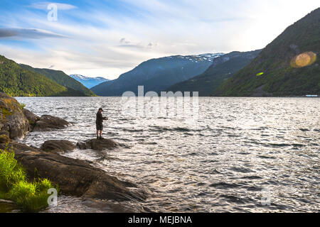 Il pescatore a fiordo in tarda serata, Norvegia, Riva del Kjornes al tramonto, Kjornes area camping presso l'Sogndalsfjorden Foto Stock