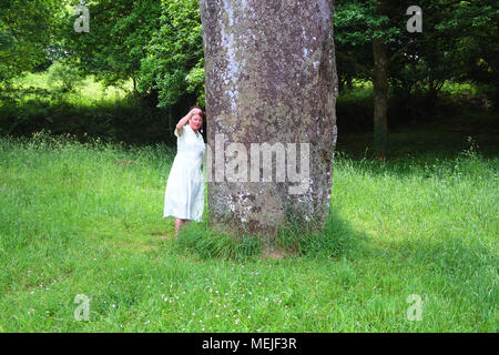 Femmina con un pendolo e radioestesia il Menhir de Kerampeulven, Huelgoat, Brittany, Francia - Giovanni Gollop Foto Stock