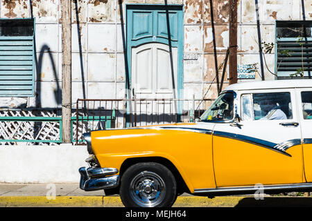 Un vecchio classico americano auto essendo azionato al di fuori di un edificio tradizionale a Varadero, Cuba. Foto Stock