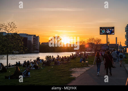 Berlino, Germania - Aprile 2018: i giovani a piedi a muro di Berlino ( East Side Gallery) sul giorno di estate serata con il cielo al tramonto Foto Stock