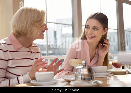 Ragazza gioiosa a pranzo con la sua nonna Foto Stock