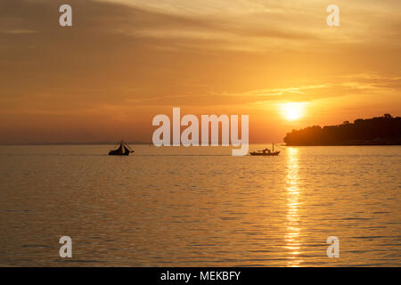 Silhouette di imbarcazioni nautiche contro ora d'oro tramonto Foto Stock