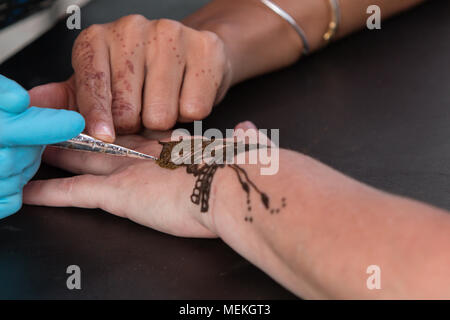 Atlanta, GA, Stati Uniti d'America - 12 Settembre 2015: un artista abilmente progetta un henné tattoo temporanei su di una donna e in mano a 5 Arts Fest di Atlanta. Foto Stock