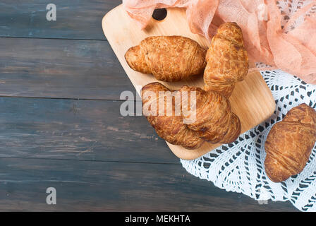 In casa freschi e gustosi croissant al cioccolato su sfondo di legno Foto Stock