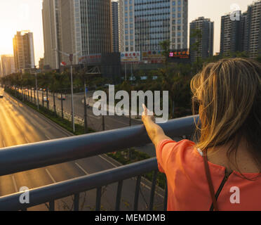 Il tramonto sulla città con modello femminile Foto Stock