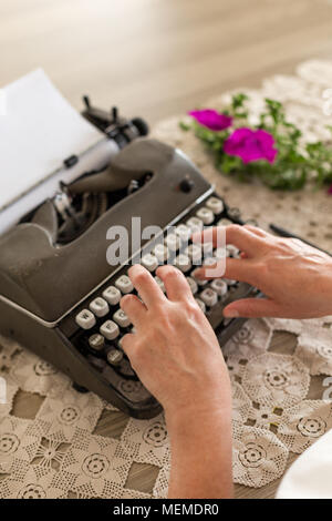 Concetto di scrittura. Le mani del medio evo woman digitazione sul retro della macchina da scrivere. Foto Stock