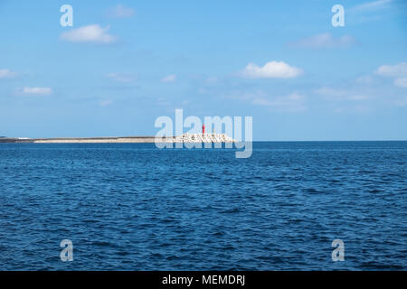 Faro rosso con wavebrakers in una giornata di sole in spiaggia Yongmeori, Sanbang-ro, Jeju Island, Corea del Sud Foto Stock