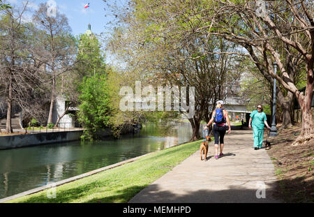 Due persone passeggiate con il cane dal fiume San Antonio, San Antonio, Texas, Stati Uniti d'America Foto Stock