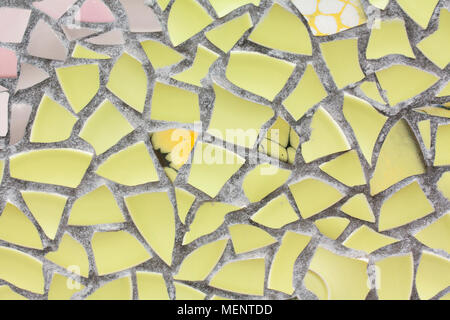 Il mosaico giallo parete dal pezzi rotti di piastrelle ceramicporcelain Foto Stock