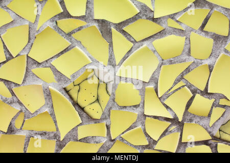 Il mosaico giallo parete dal pezzi rotti di piastrelle ceramicporcelain Foto Stock