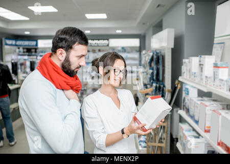 Il farmacista con il client in farmacia store Foto Stock