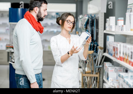 Il farmacista con il client in farmacia store Foto Stock