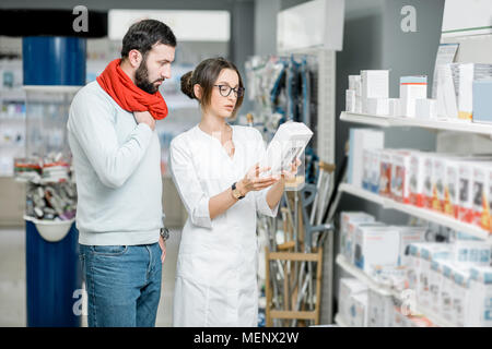 Il farmacista con il client in farmacia store Foto Stock