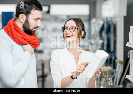 Il farmacista con il client in farmacia store Foto Stock