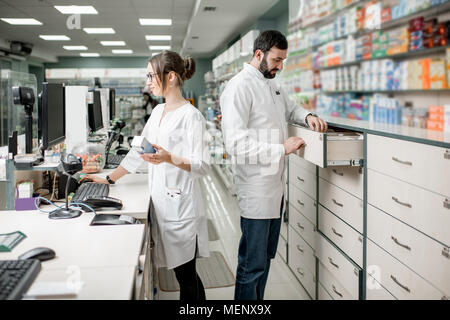 I farmacisti che lavorano in farmacia store Foto Stock