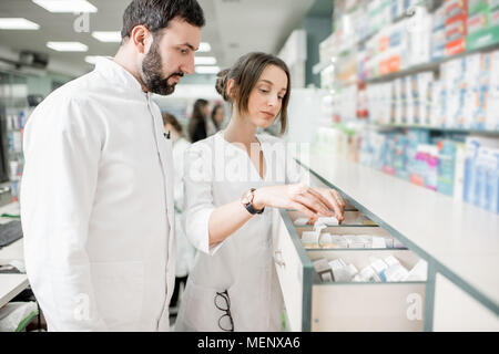 I farmacisti che lavorano in farmacia store Foto Stock