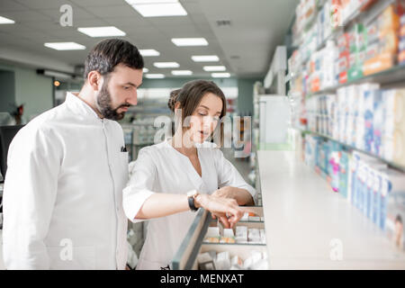 I farmacisti che lavorano in farmacia store Foto Stock