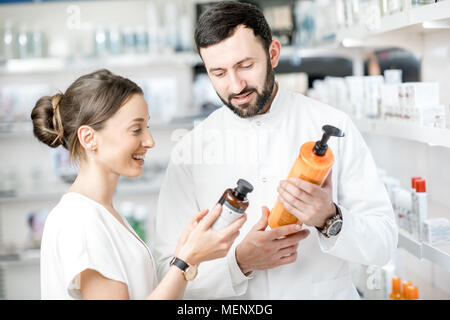 Il farmacista con il client in farmacia store Foto Stock