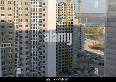 Interno posto per molti alti edifici in costruzione e gru sotto un cielo blu Foto Stock