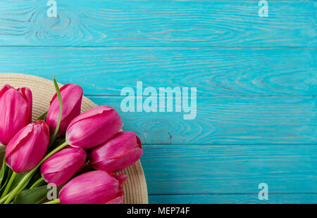 Donna Accessori - hat e bouquet di tulipani rosa su uno sfondo di legno. Messa a fuoco selettiva. Foto Stock