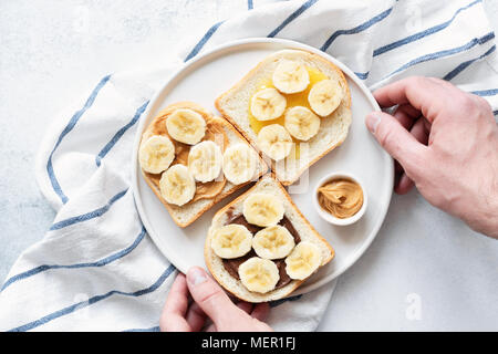 Vegano sano, toast con burro di dado e banana. Vista dall'alto. Cibo vegan, vegetariano, mangiare sano, uno stile di vita sano, dieta e fitness concetto di menu Foto Stock