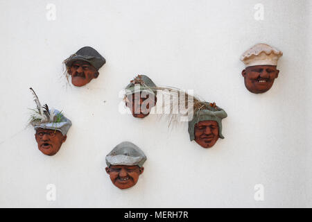 Un gruppo di vecchi vasi per piante che assomigliano a facce attaccato ad una parete a Bognor Regis, West Sussex, Regno Unito. Foto Stock