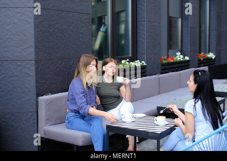 Amici di sesso femminile a bere caffè e seduta al cafe. Foto Stock