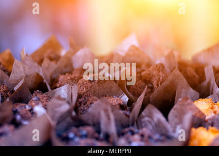 Close-up di fresco muffin al cioccolato, decorata con cioccolato e con cioccolata calda all'interno di righe pari Foto Stock
