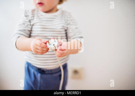 Il Toddler boy in una situazione di pericolo a casa. Foto Stock