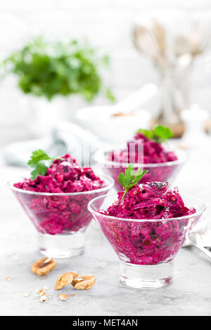 Insalata di barbabietole. Insalata di bollito di barbabietole. La barbabietola rossa con insalata di potare le noci e la panna acida su sfondo bianco Foto Stock