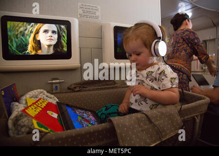 1 anno vecchio guardando cartoni animati su iPad su voli di lungo raggio Foto Stock