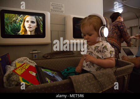 1 anno vecchio guardando cartoni animati su iPad su voli di lungo raggio Foto Stock